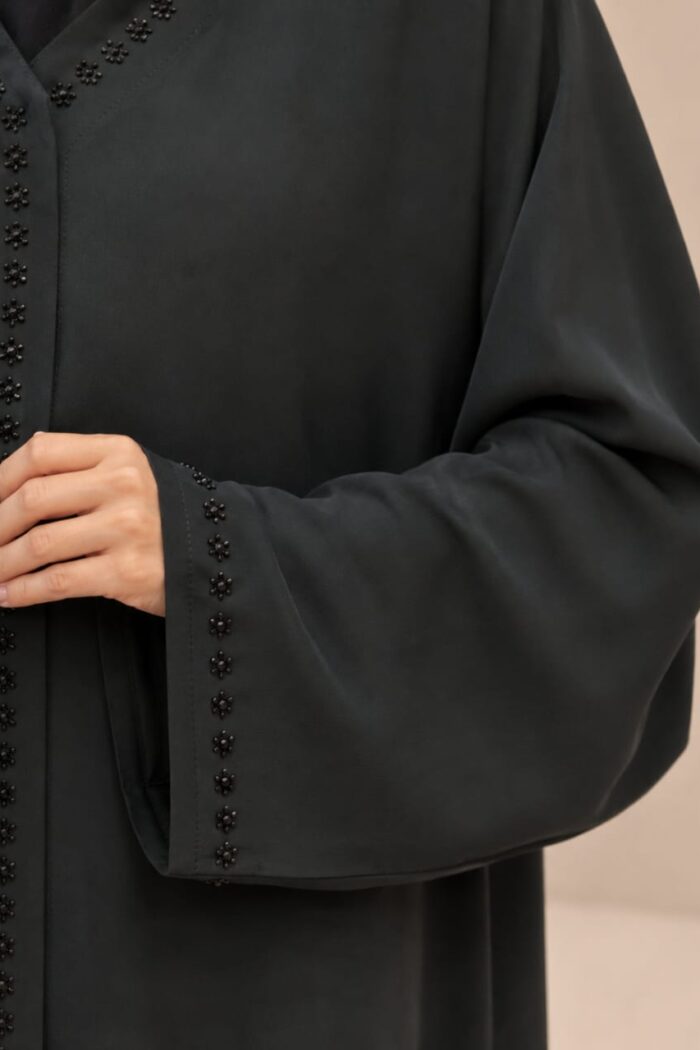 Close-up of floral stone embroidery on juba abaya front and cuff
