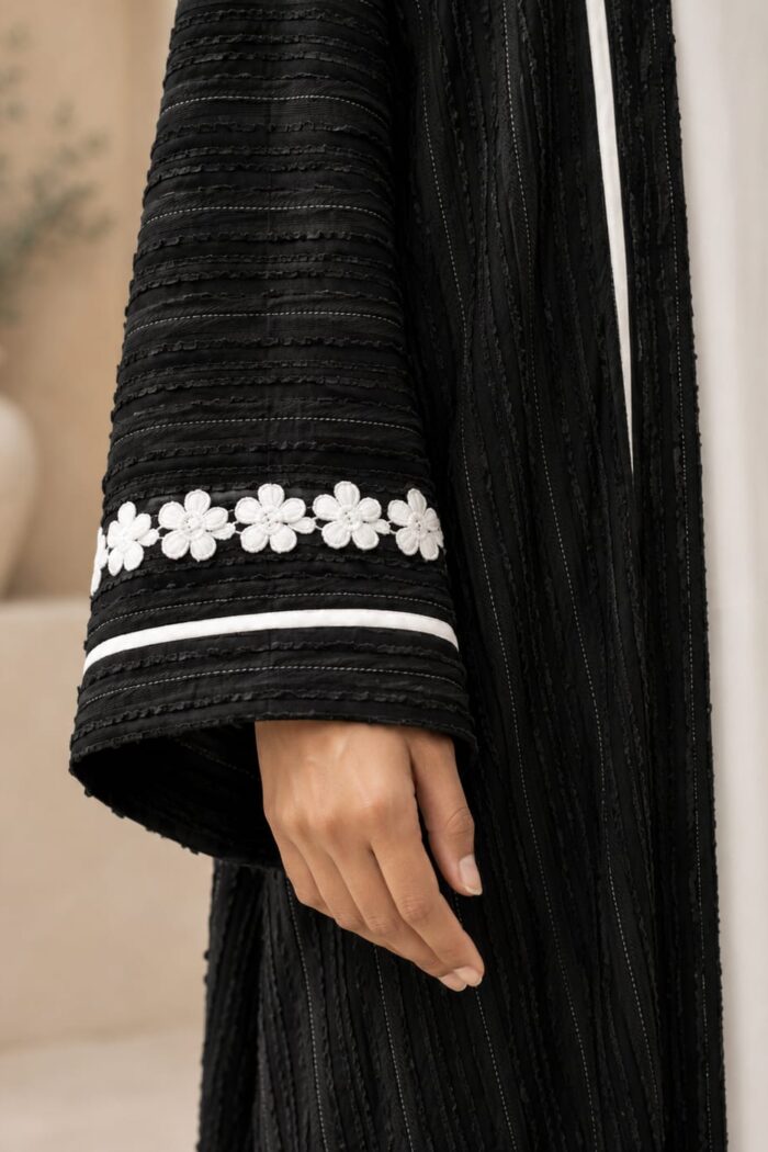 Green velvet abaya close-up of floral cuff embroidery and white piping