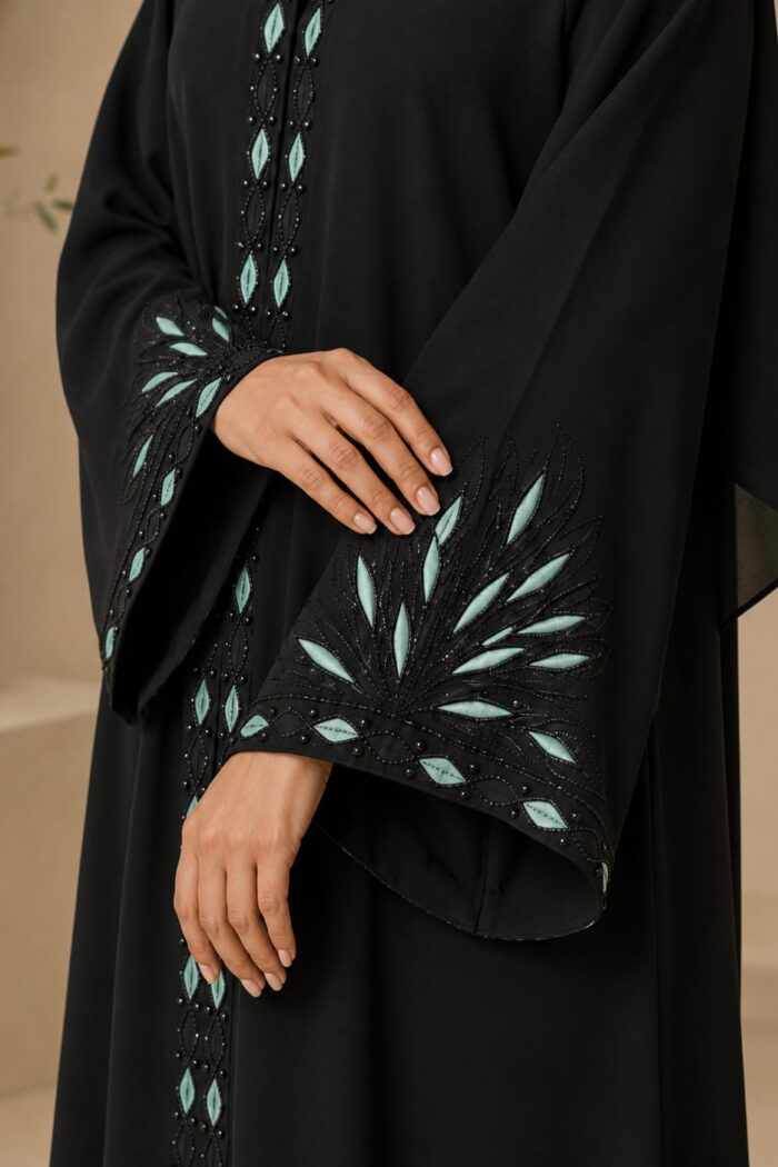 Close-up of mint leaf karahi embroidery with black stones on abaya cuff