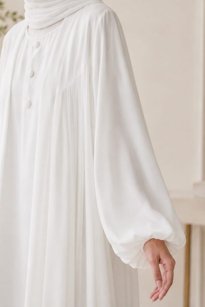 Mazdoja Plates Abaya in white, close-up of chunt-style cuff and front pleat detail