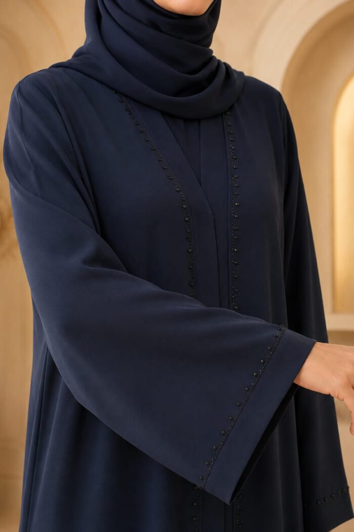Close-up of stone embroidery on navy blue juba abaya neckline and cuff