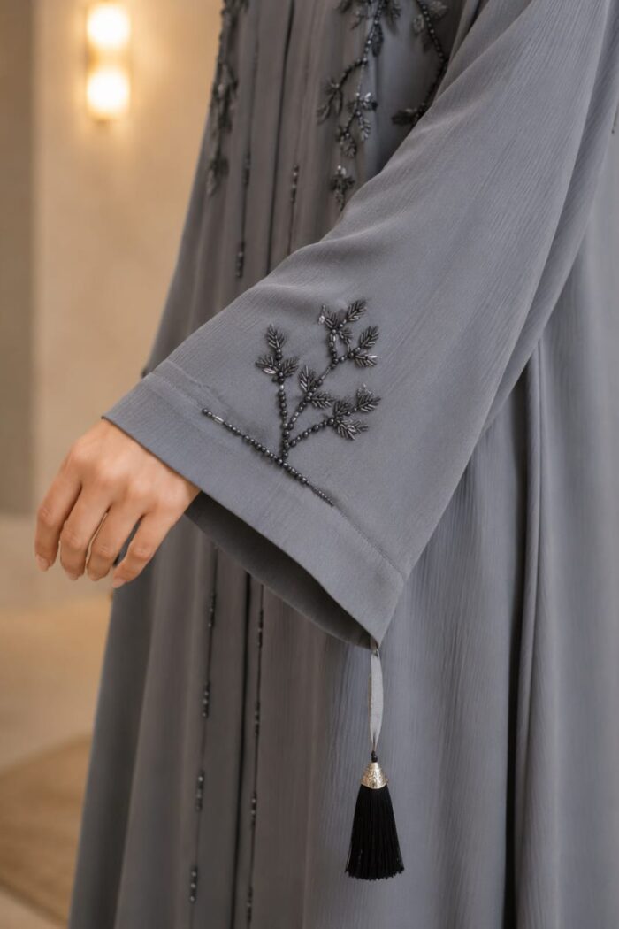 Zoom Arabian Katdana Abaya in cashmere silver, close-up of katdana beaded embroidery and tassel on cuff