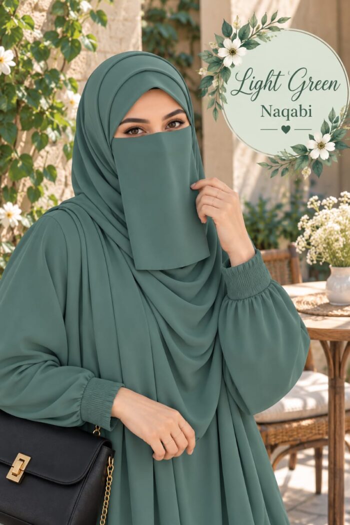 Woman wearing a light green pastel Dori Naqabi with matching hijab and abaya beside a garden table